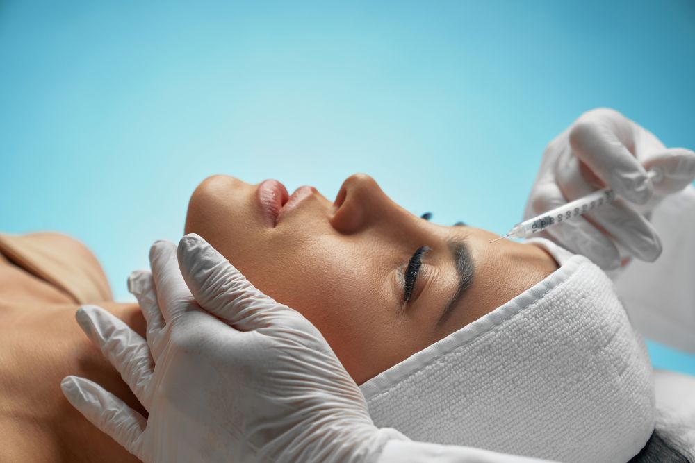 Woman receiving botox injection, aesthetic treatment, skincare procedure.